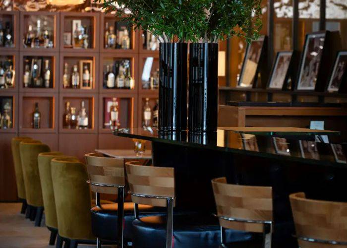 The chic Italian-inspired interiors of Bulgari Ginza Bar, featuring warm woods and natural greens.